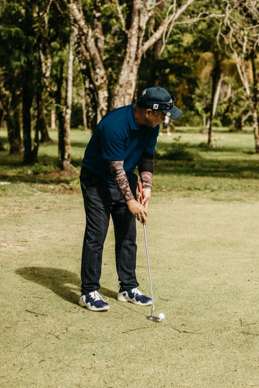 a man who is playing golf in the grass