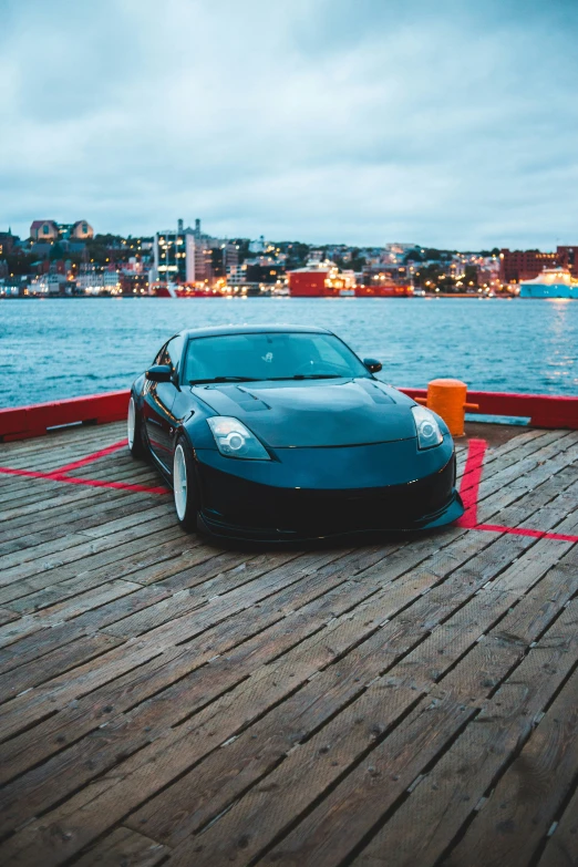a black sports car parked on a wooden pier