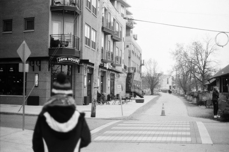 people walking down the sidewalk in front of some houses