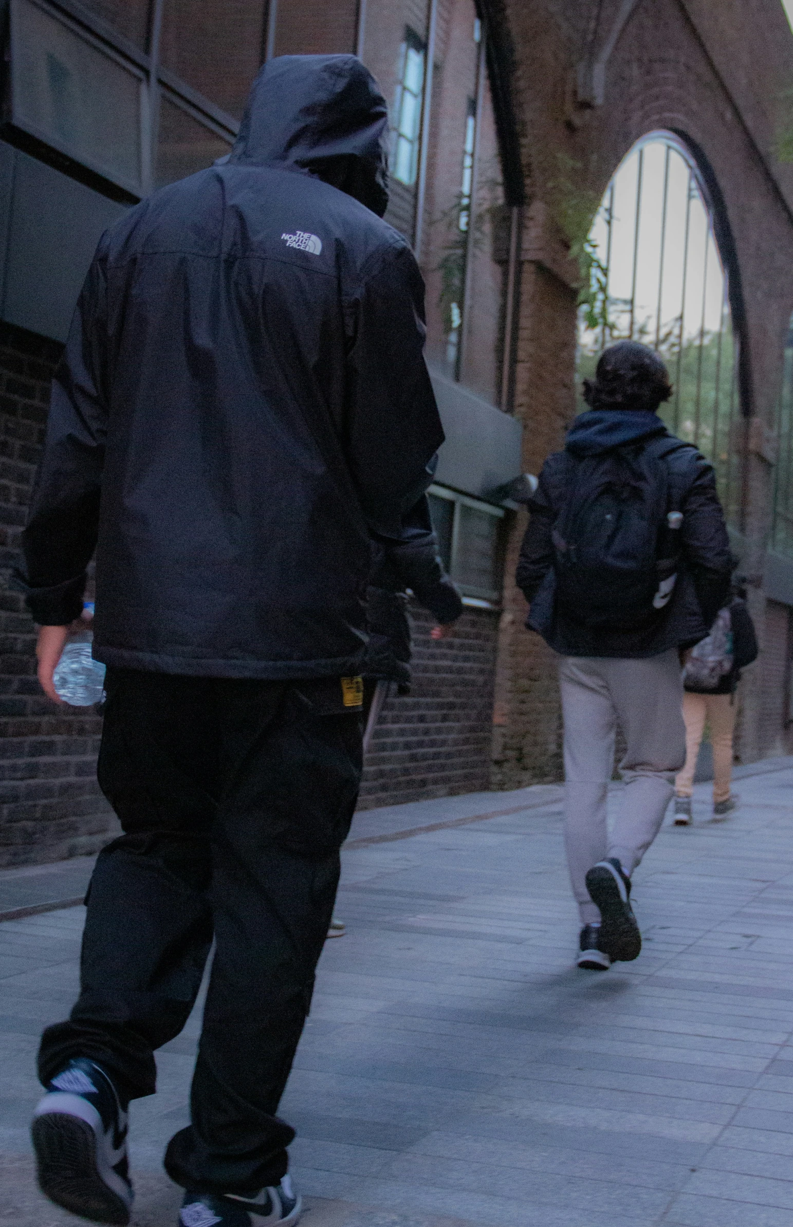 two men skateboard in a busy urban area