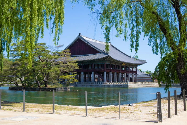 a pavilion is built across the water from an open area