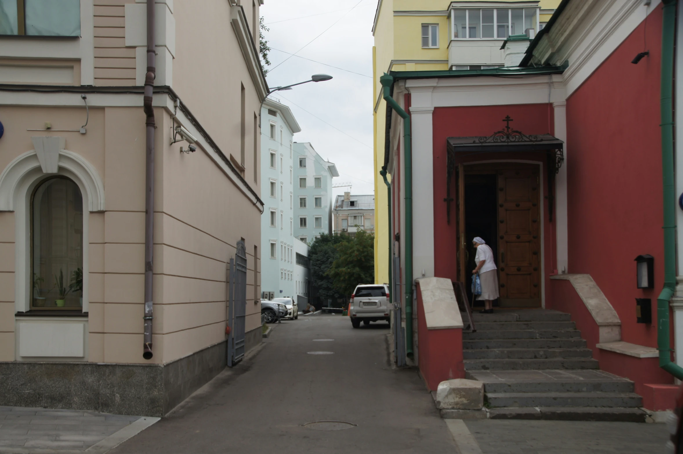 two people standing in doorways on the side of a building