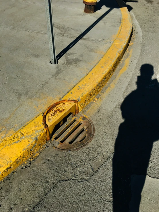 a man standing on the sidewalk next to a yellow fire hydrant