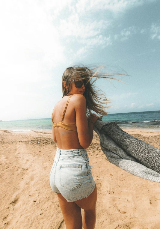 a young woman on the beach holding an animal