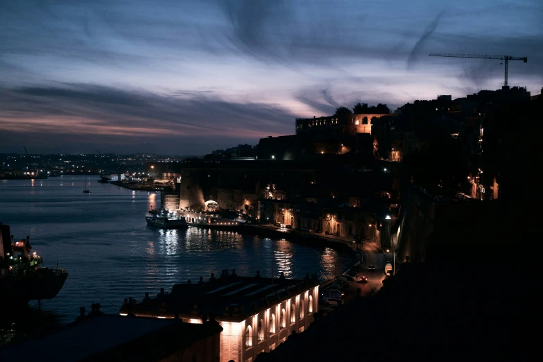 a night view of a city with buildings by the water