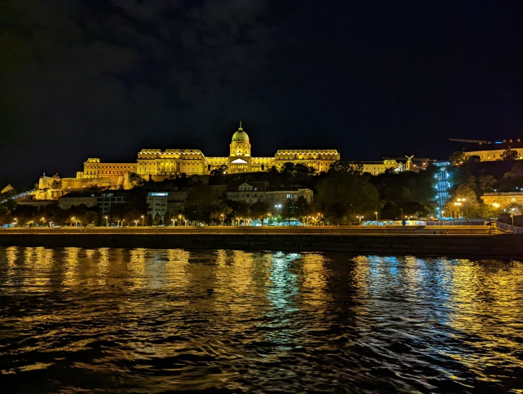 a dark sky at night shows the castle across the water