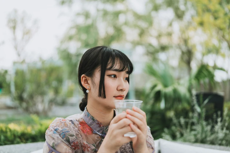 a woman drinking out of a plastic cup