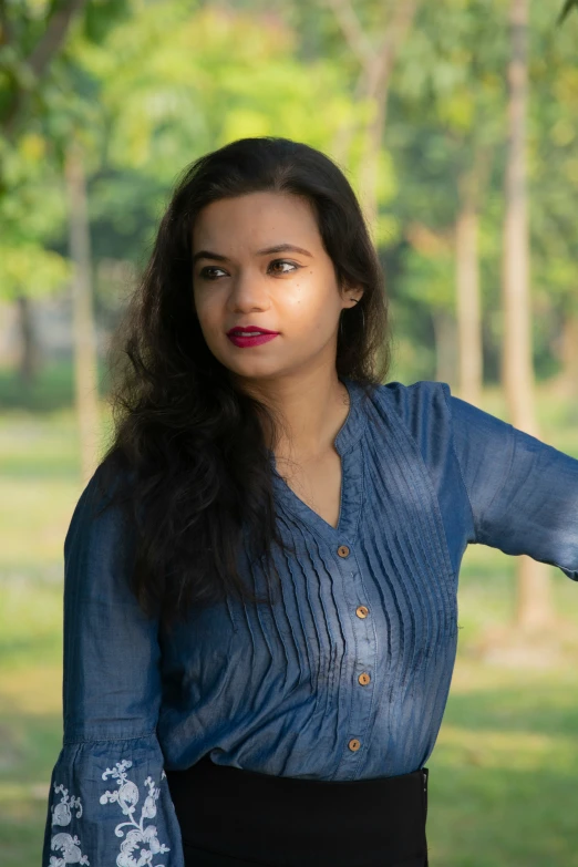 a woman wearing a blue shirt and skirt