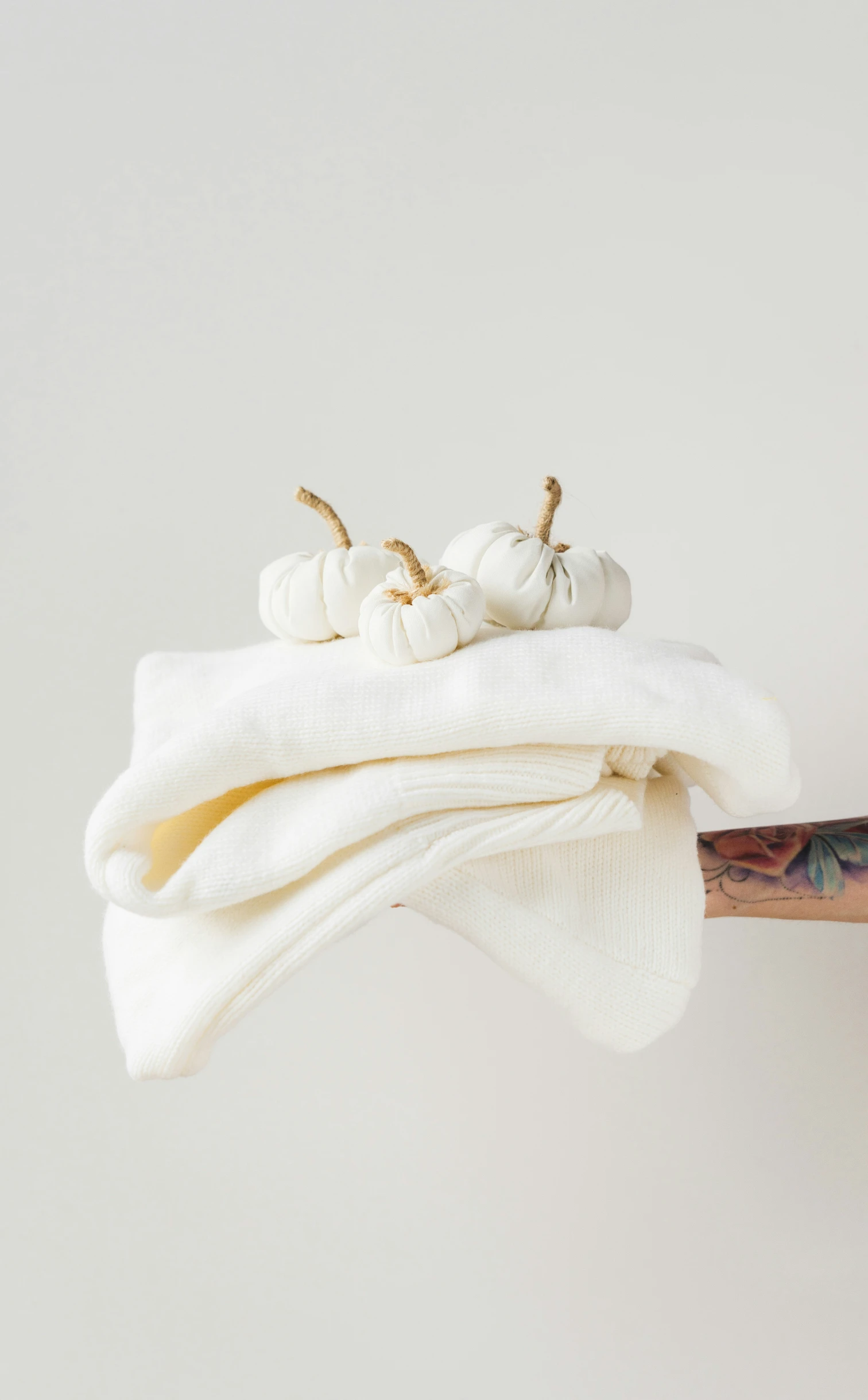 there are three little pumpkins laying on top of a white towel