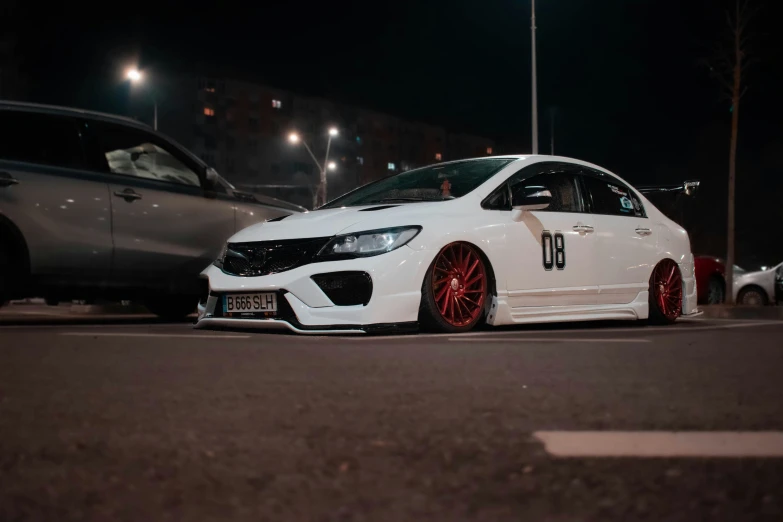 a white car parked on the street at night