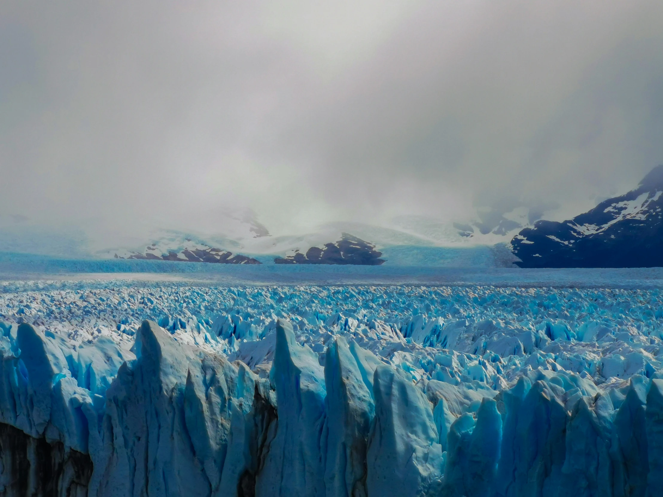 a large glacier is shown with blue ice