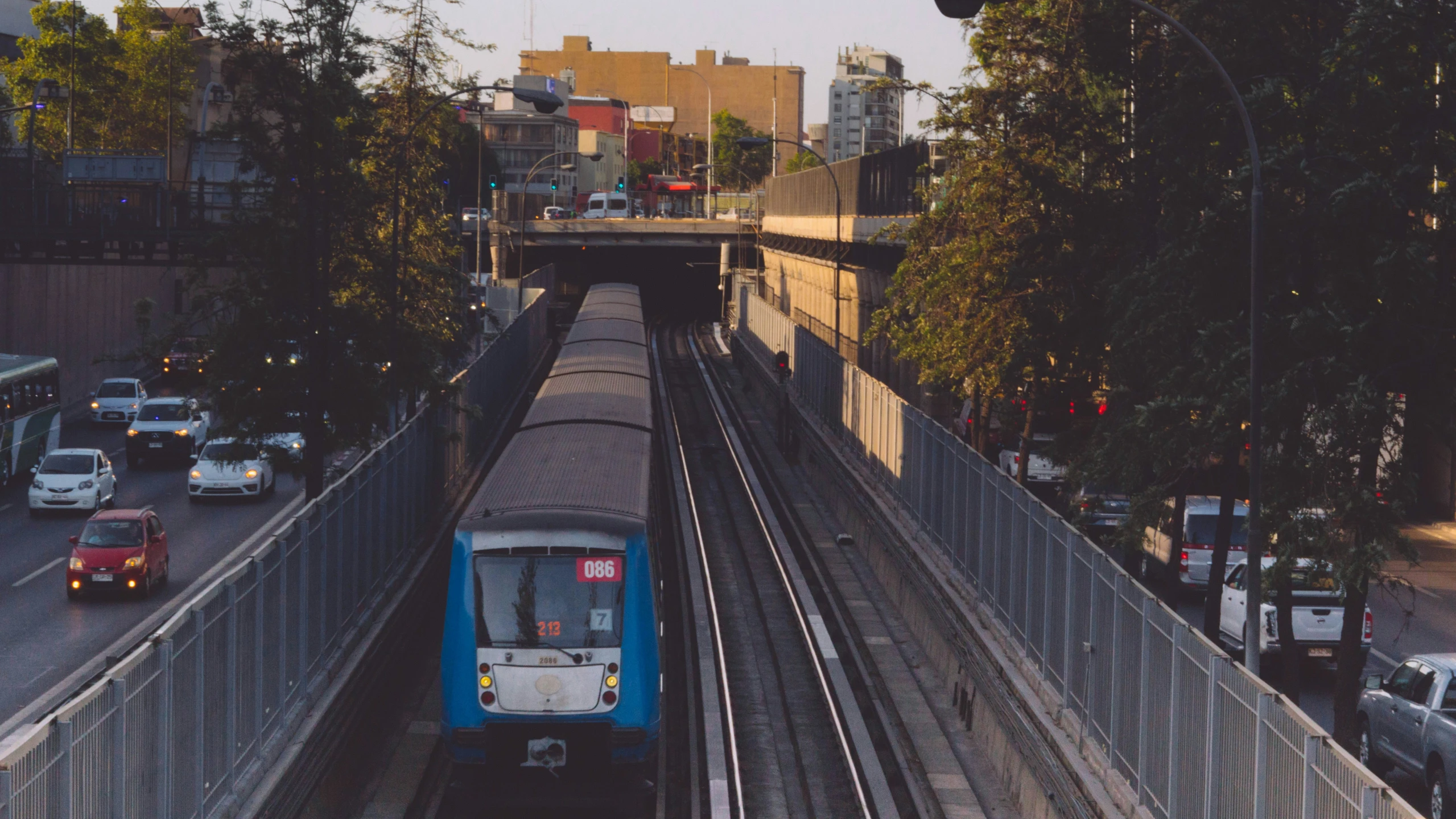 train coming into the tunnel with cars on either side