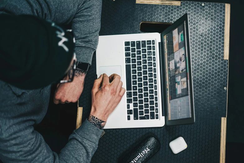 a man is typing on a laptop at a desk