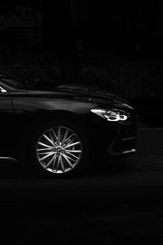 a black car with white wheels in the dark