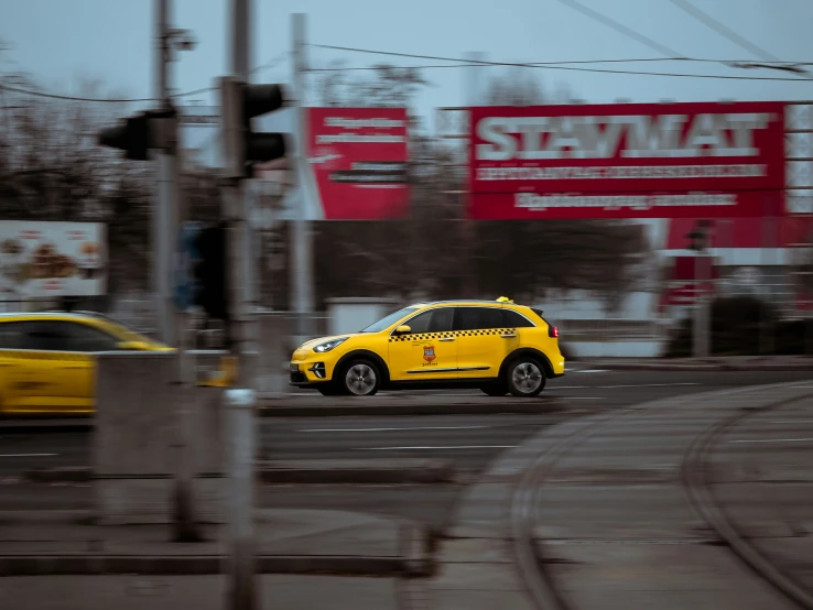 a yellow car going past a city traffic light