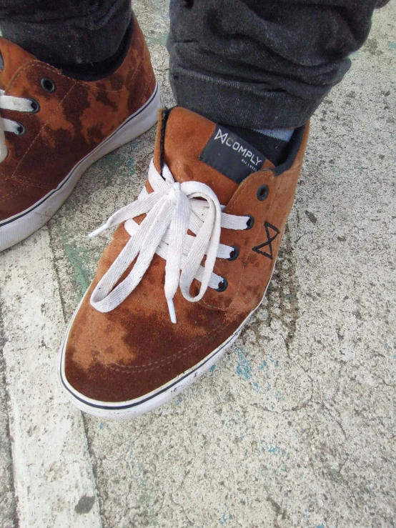 closeup view of shoes and jeans, with a person wearing brown sneakers