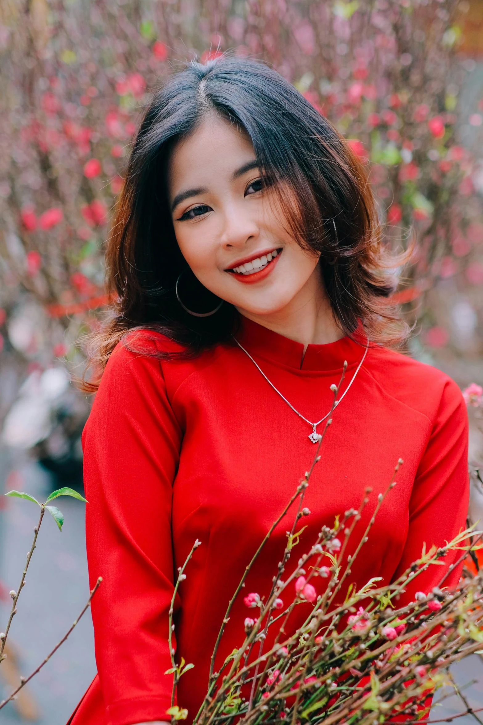 a woman smiling while holding some flowers