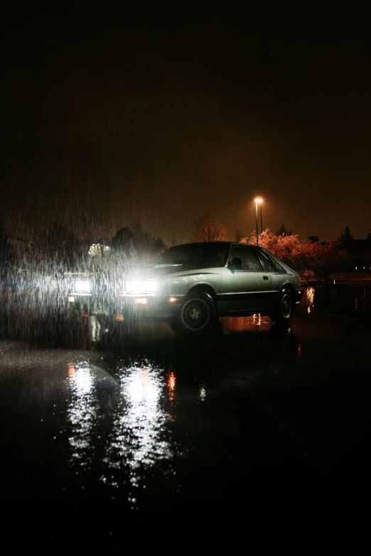 a white car driving on top of a rainy road