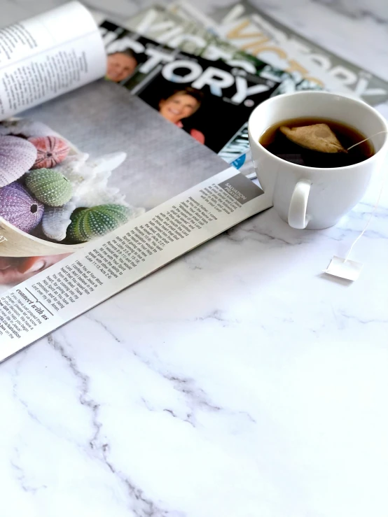 a cup of coffee sitting on top of a magazine