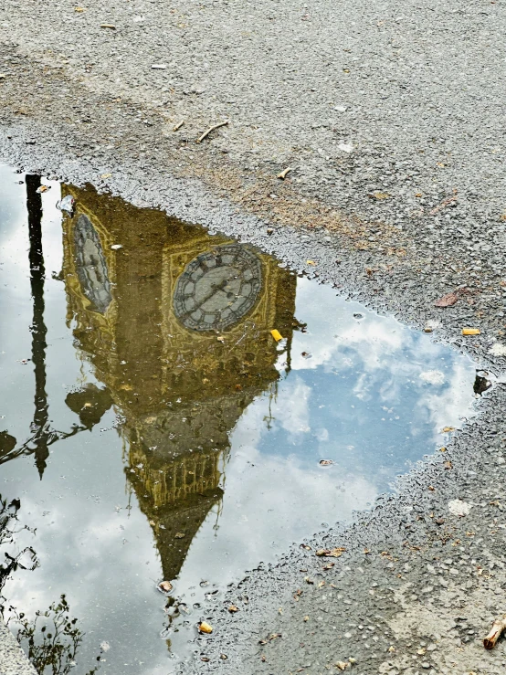 a clock tower sitting on the corner of a dle of water