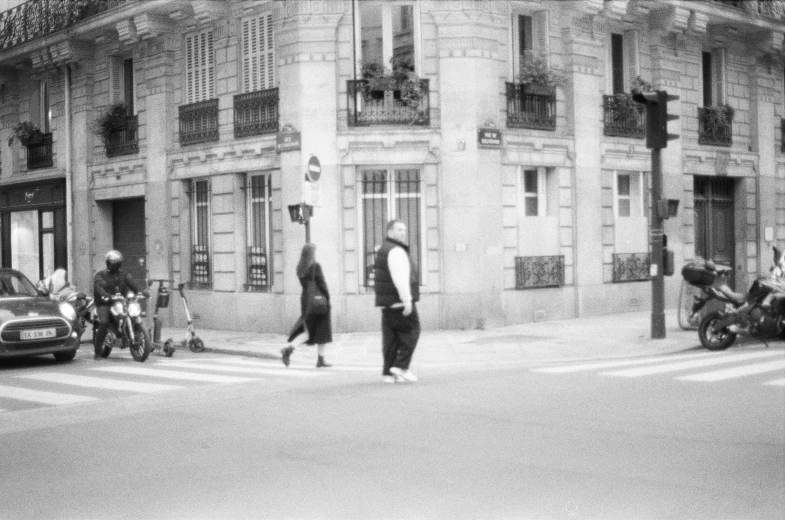 an old black and white po shows a woman walking past a building