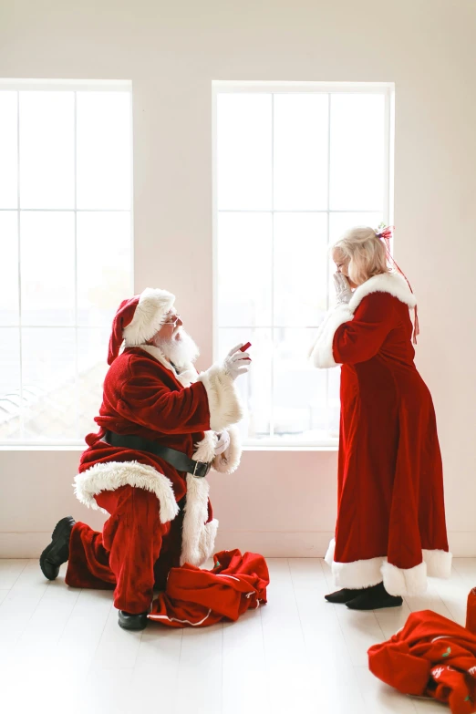 santa claus and mrs claus are sitting near the window