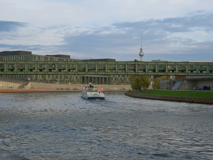 a ship passing under an overhead bridge near some buildings