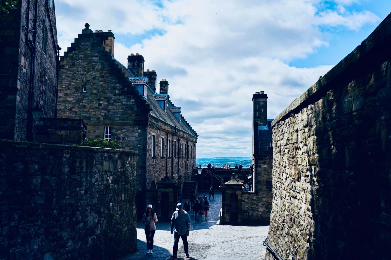 people walking on a cobble stone street in an old medieval city