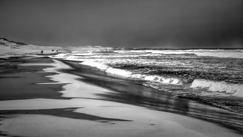 a black and white po of waves on the beach