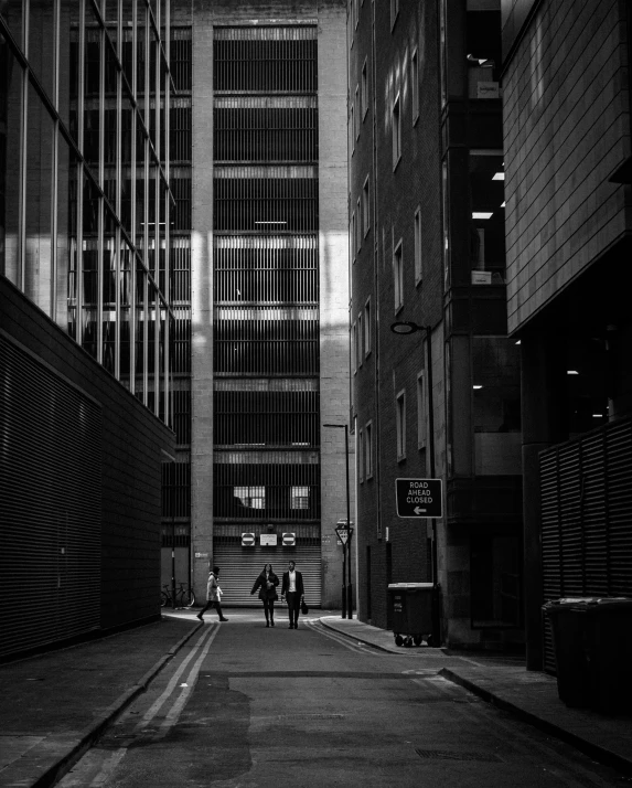 two men walking down the street in between buildings