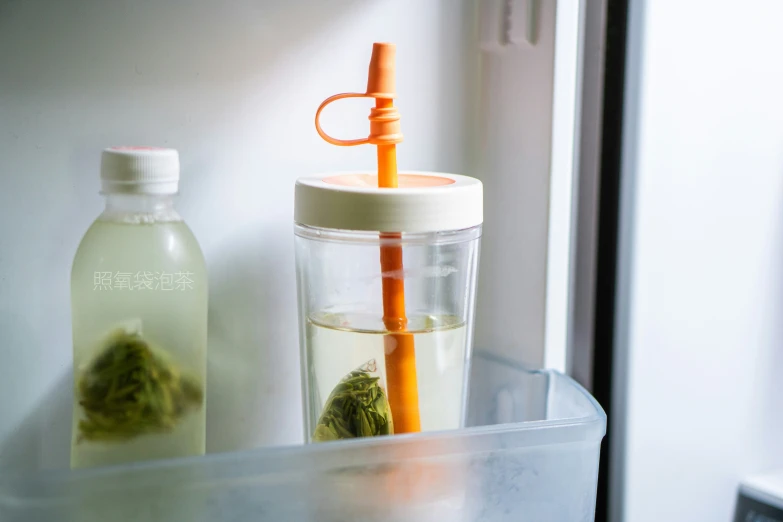 an orange straw in a cup on a glass table