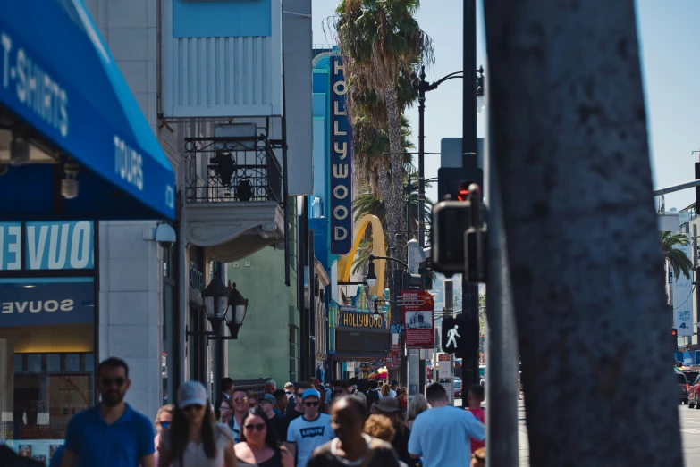 people walking down a street with tall buildings