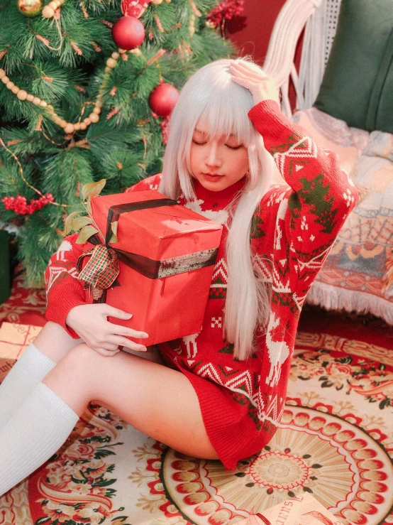 a young woman is dressed as santa clause sitting near a christmas tree