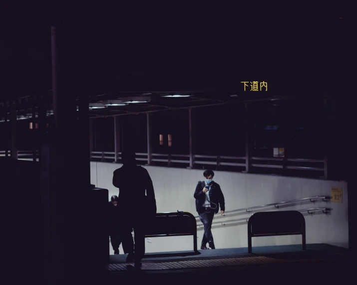 the person is walking past a bench at night