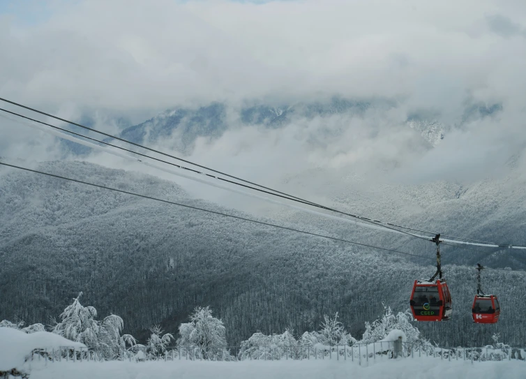 a red ski lift in the mountains with snow on them