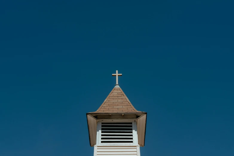 a large church steeple with a cross on the top