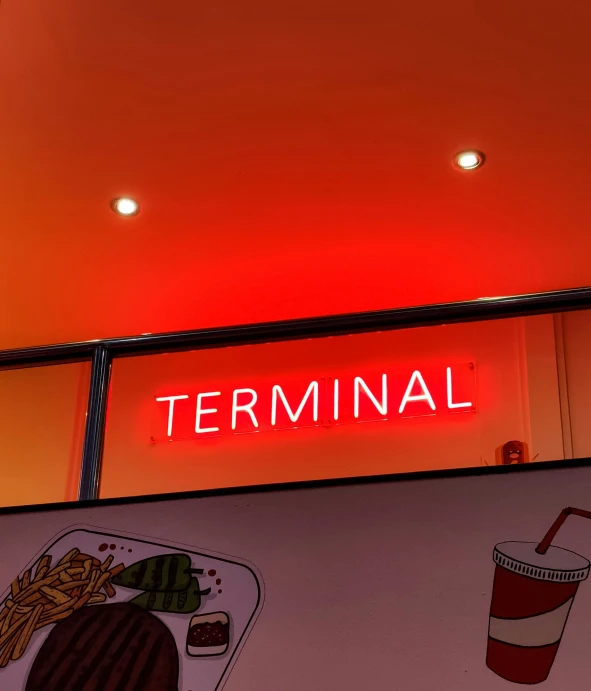 a neon sign lit up over a food stand