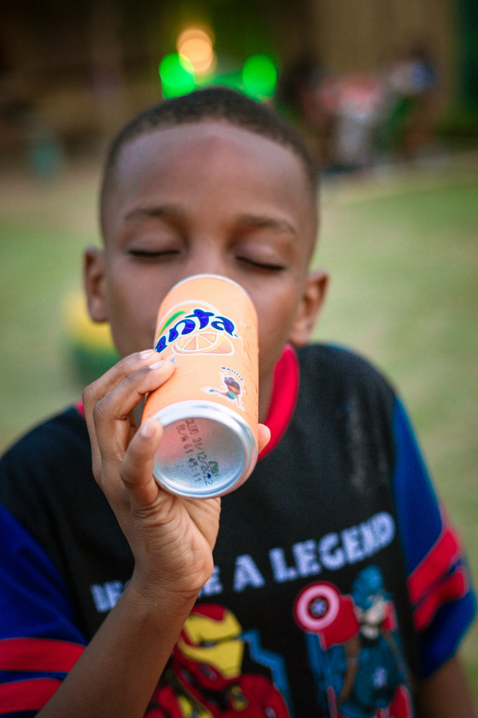 a boy who is drinking out of a can