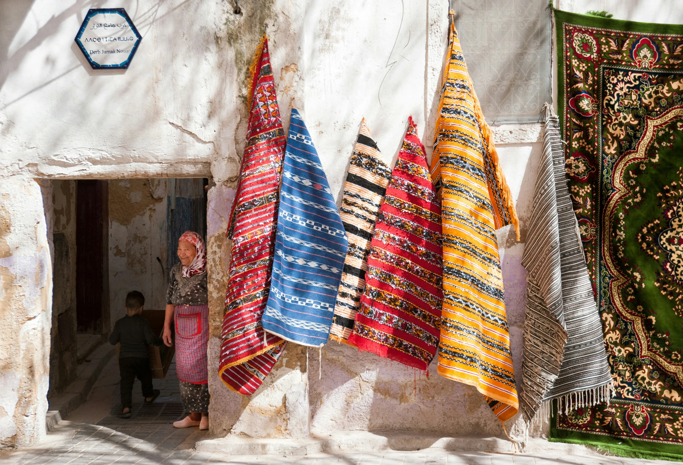 a woman standing between three hanging towels