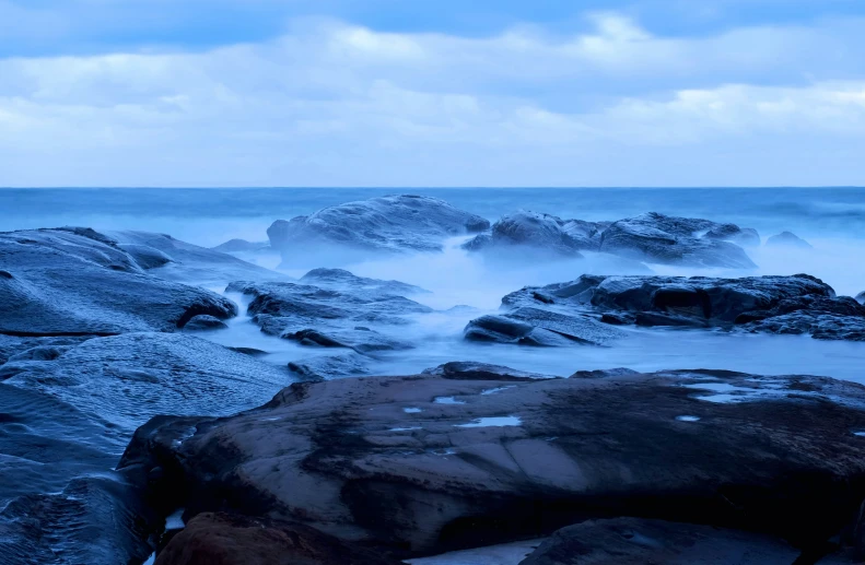 a view of the ocean from a rocky shore