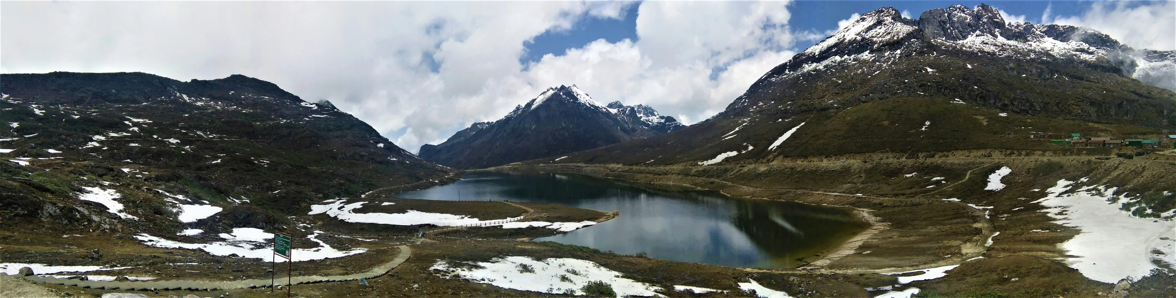 snow covered mountains rise into the sky over a lake