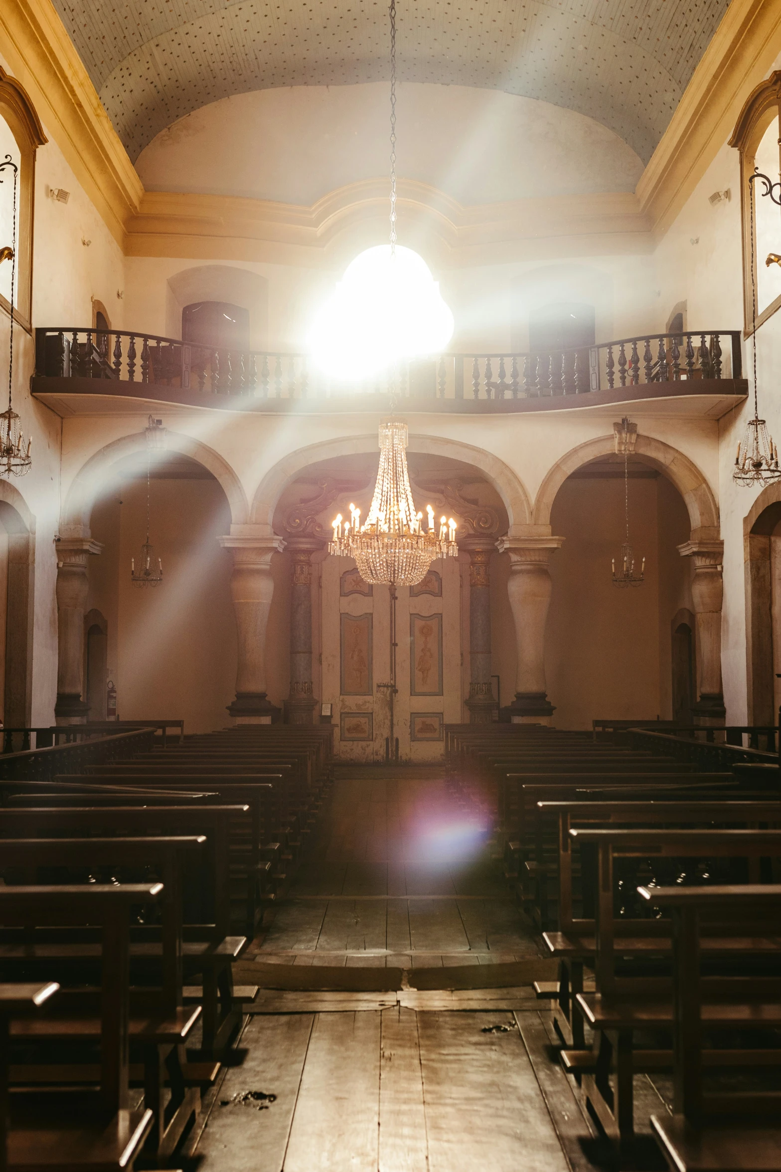 inside of a church with some pews and a chandelier