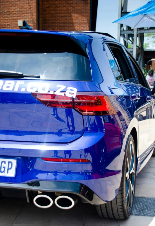 a blue vw golf parked on the side of the street