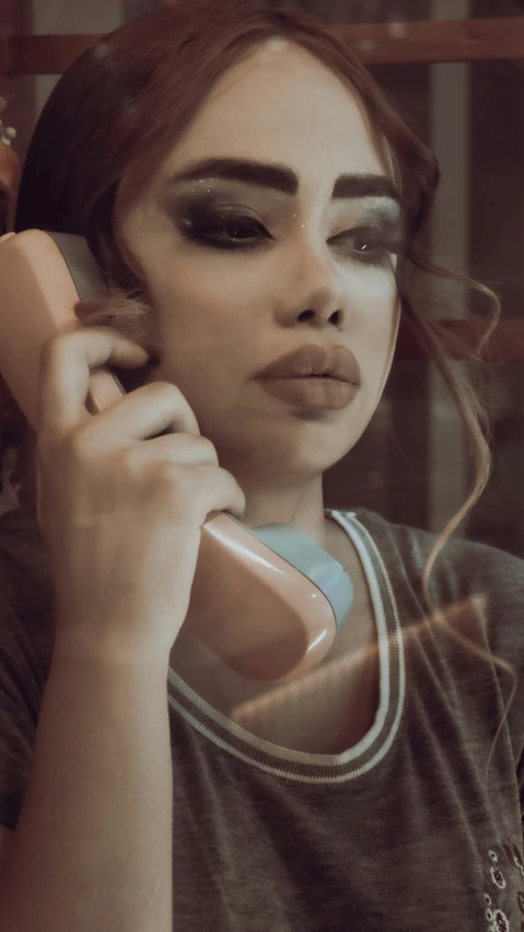 a girl holding up a cell phone to her ear