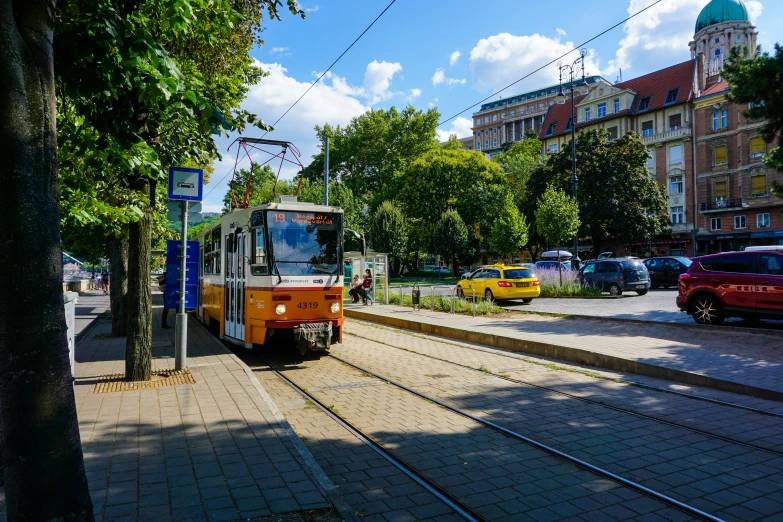 a bus stopped on the tracks near a stop sign