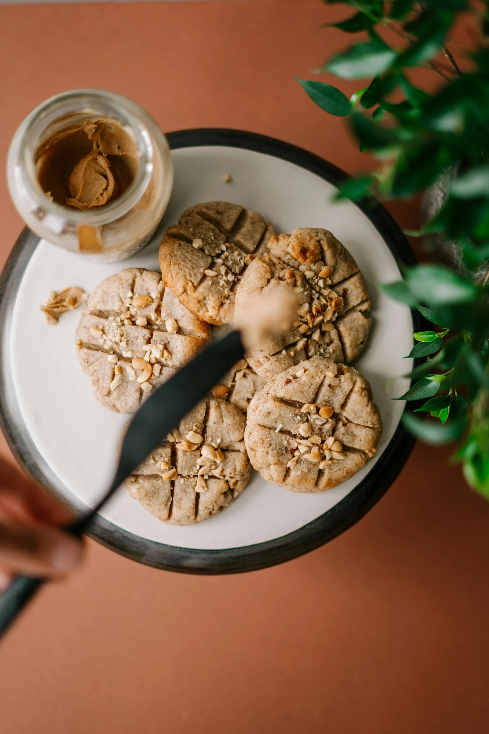 a person holding a cookie plate with a knife