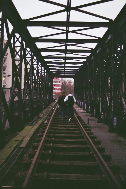 two men are standing on train tracks