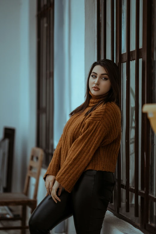 woman wearing black pants posing for po by window