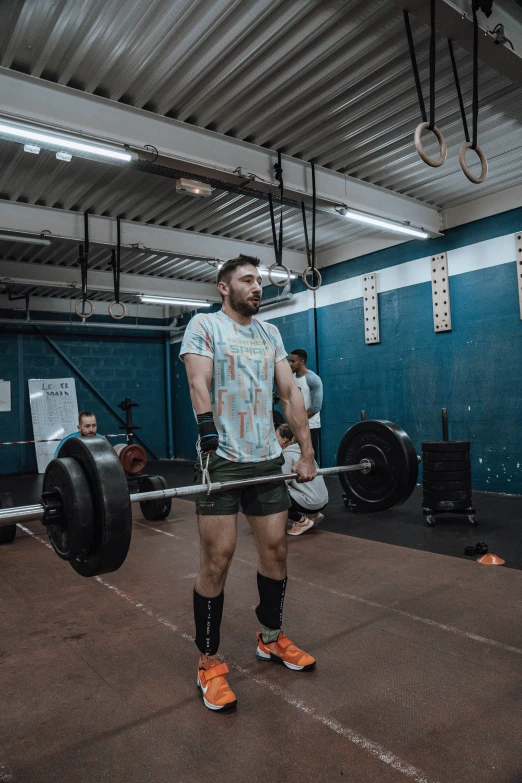 a man holding a barbell with one leg in his hand