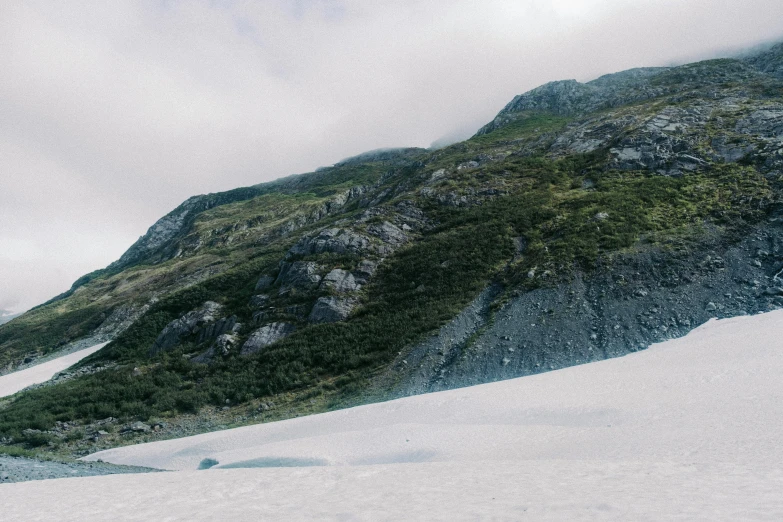 a group of people walking up the side of a snow covered mountain